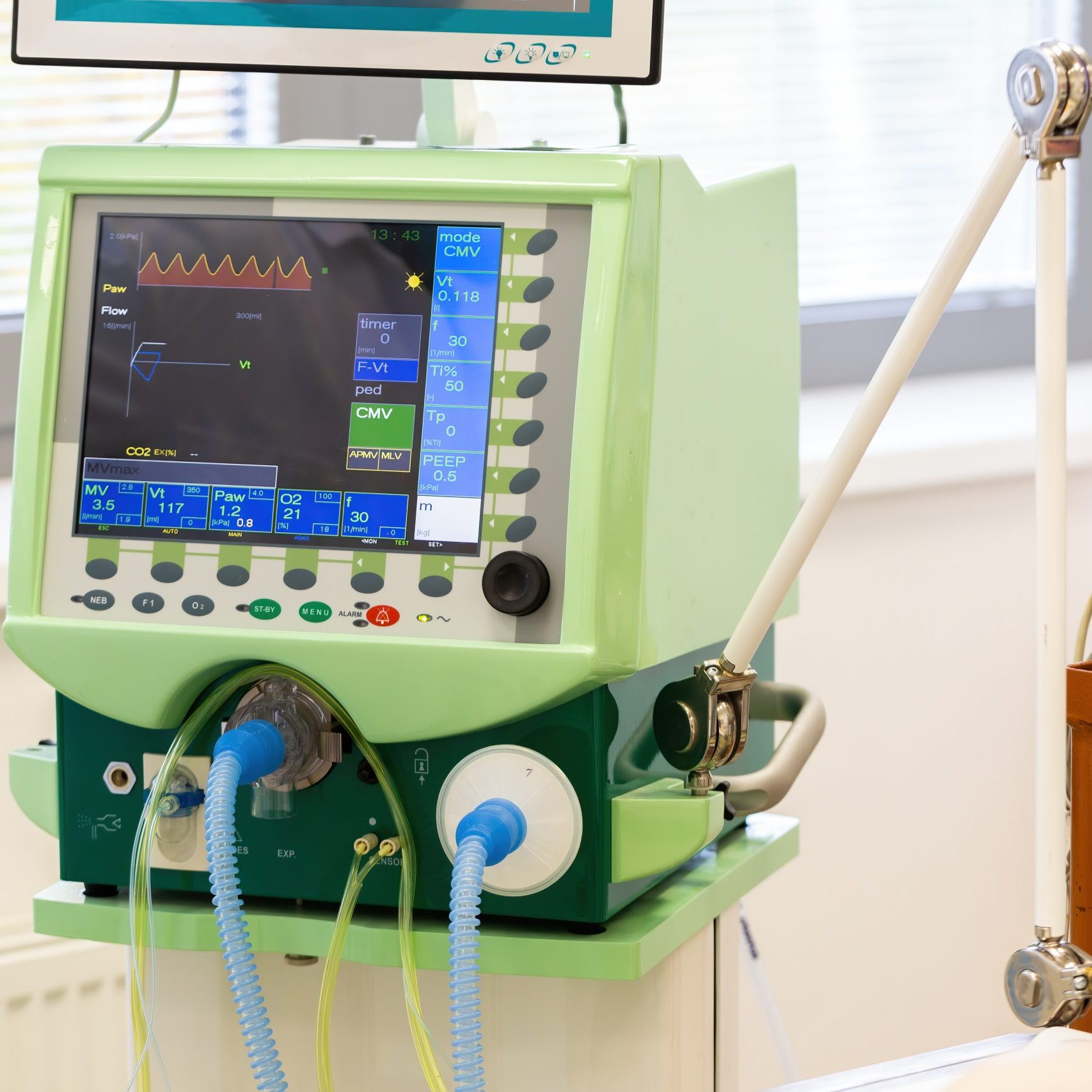 Monitor of pulmonary ventilator in hospital with tubes for air. Display with graphs used for artificial breathing assistance to patients on intensive care unit or during operations.