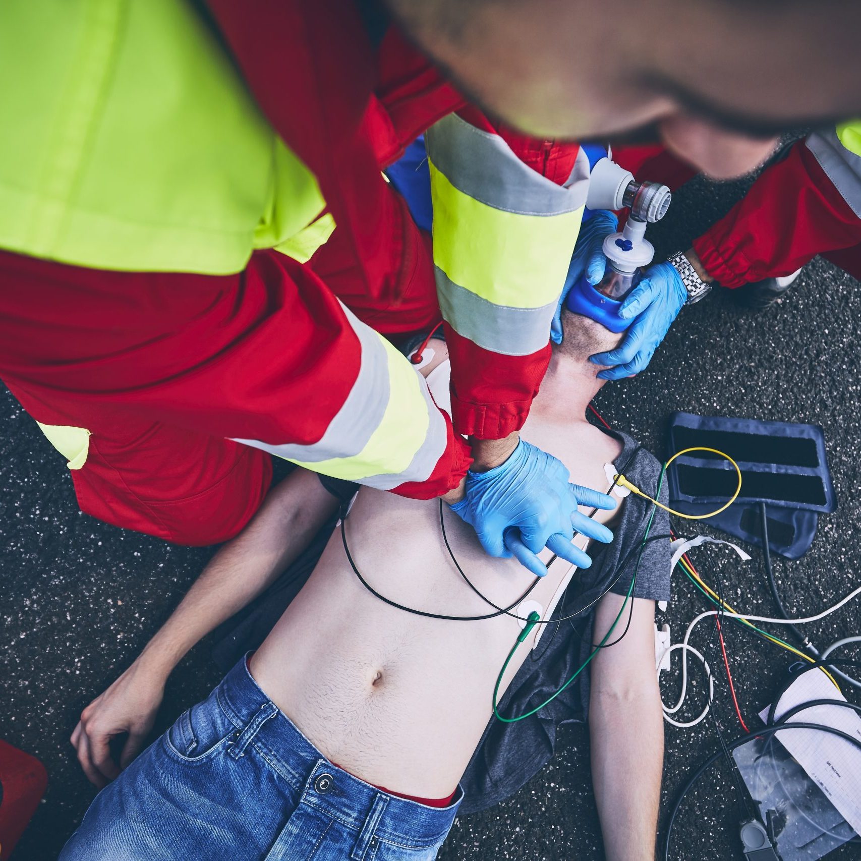 Cardiopulmonary resuscitation. Rescue team (doctor and a paramedic) resuscitating the man on the road.